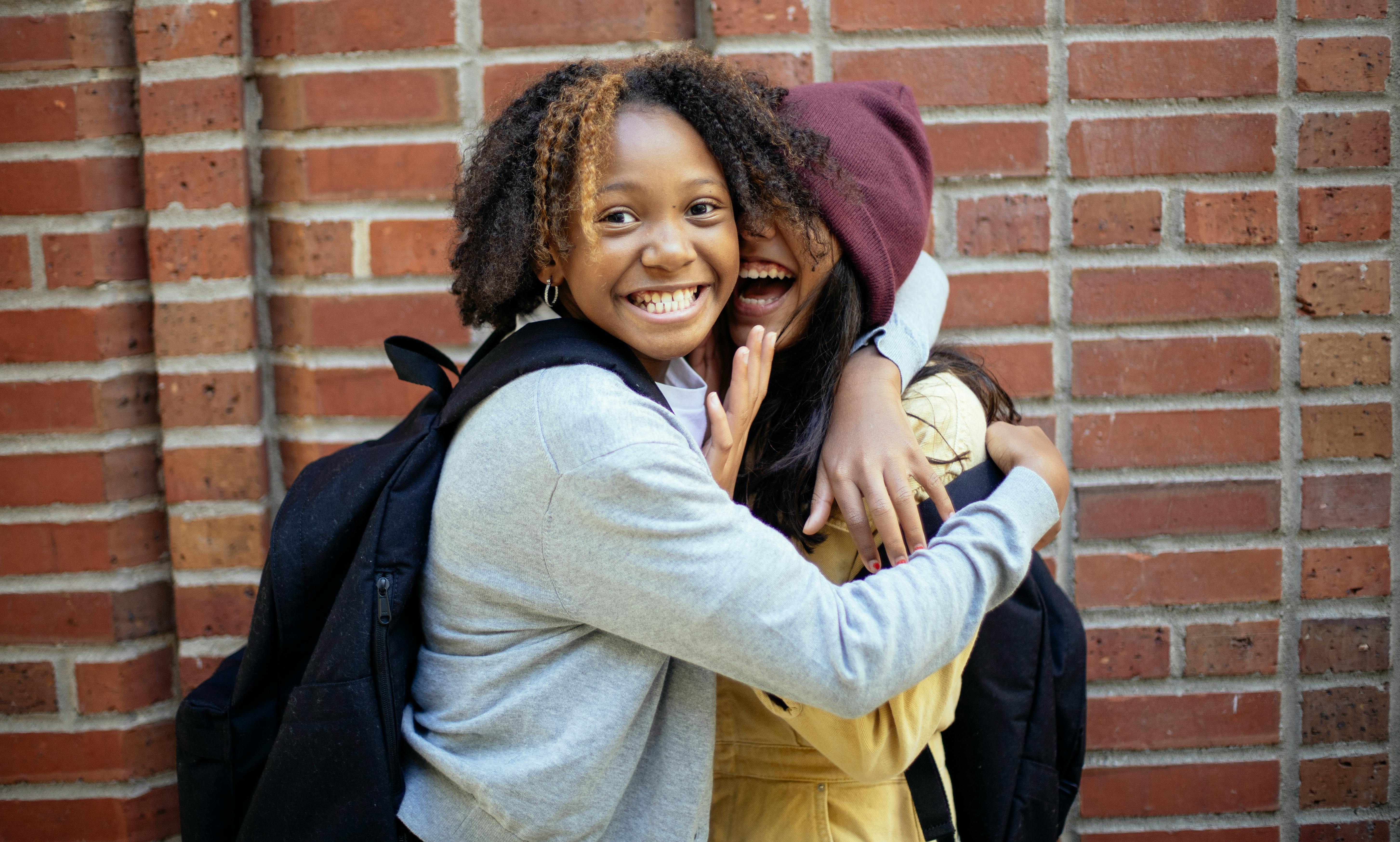 happy diverse friends against brick wall