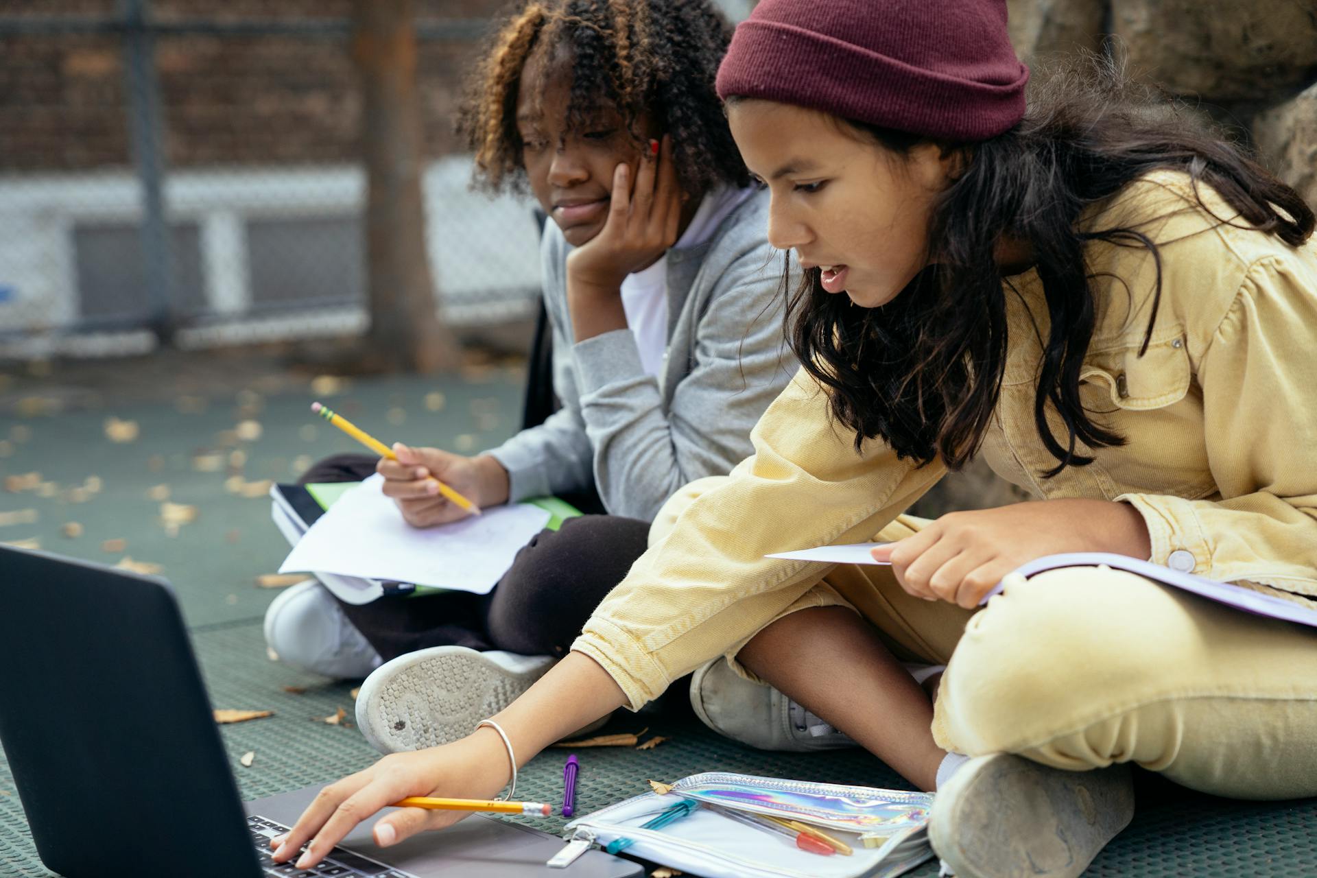 Focused girls with laptop and copybooks