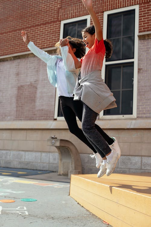 Happy girls jumping on ground · Free Stock Photo