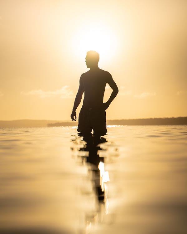 Silhouette of Man Holding a Cigarette while on the Beach