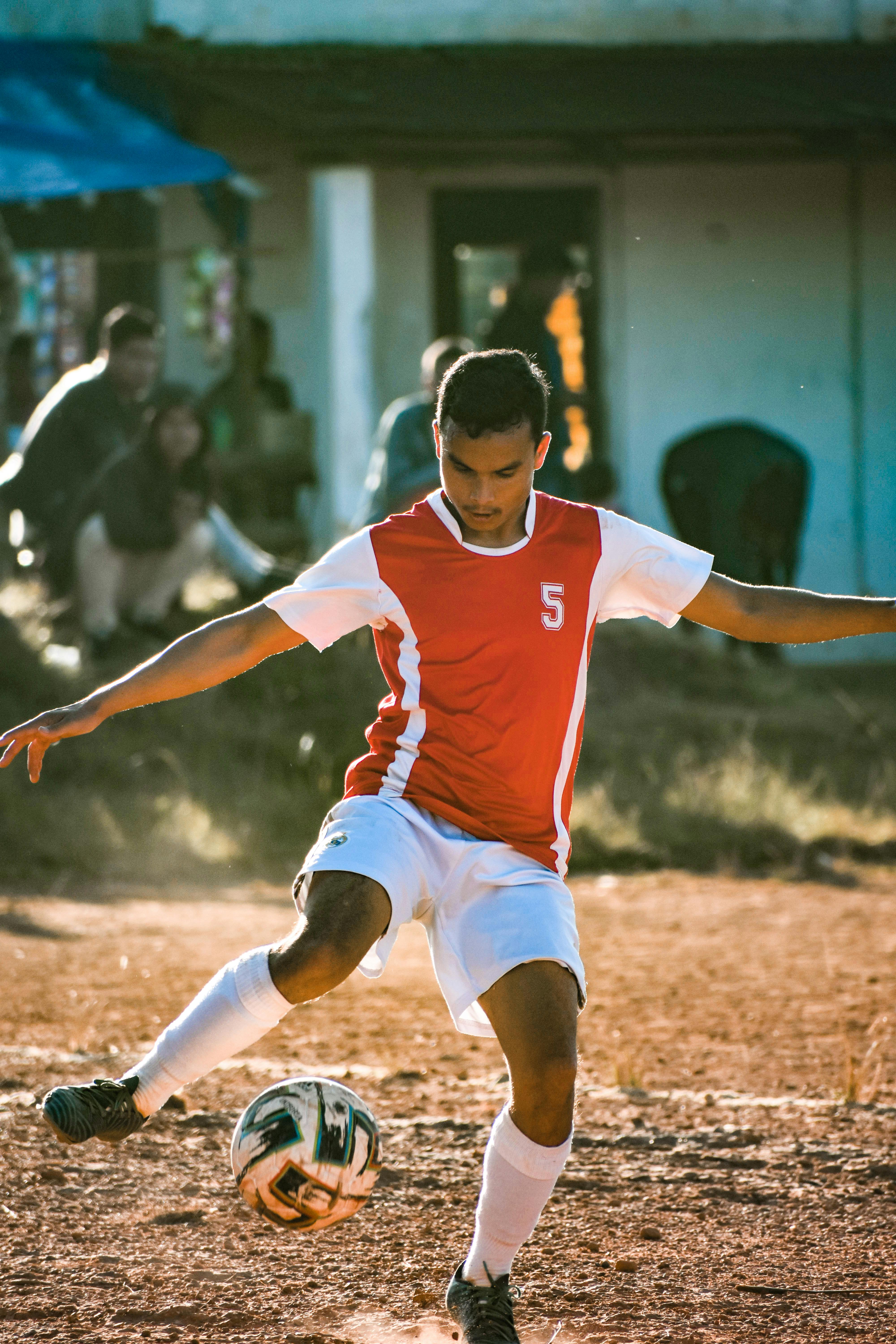 man in red jersey playing soccer