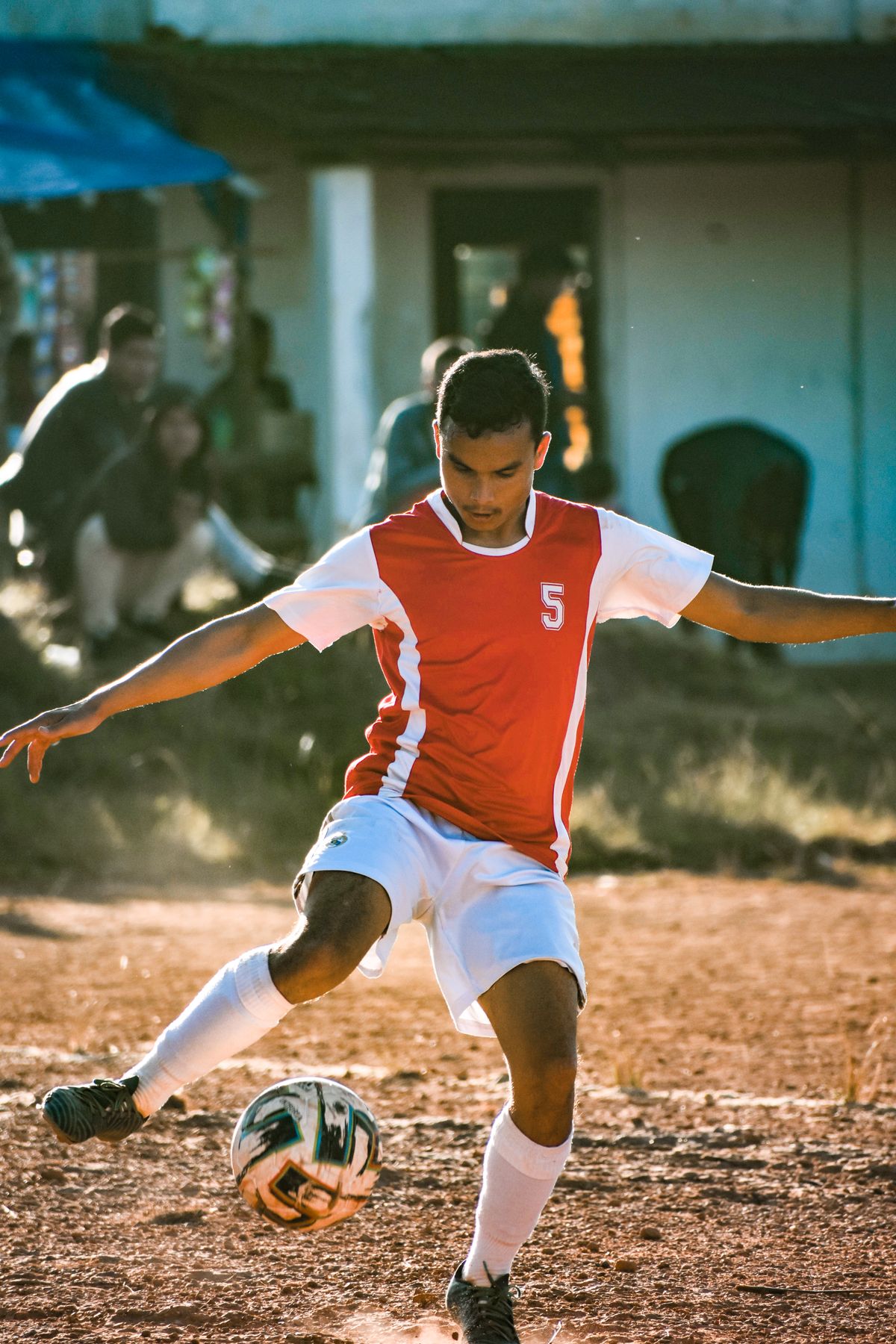 Portrait of defender Reece Thornton in a plain red and white kit