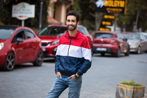 Free Man in Blue and Red Jacket Looking at the Camera Stock Photo