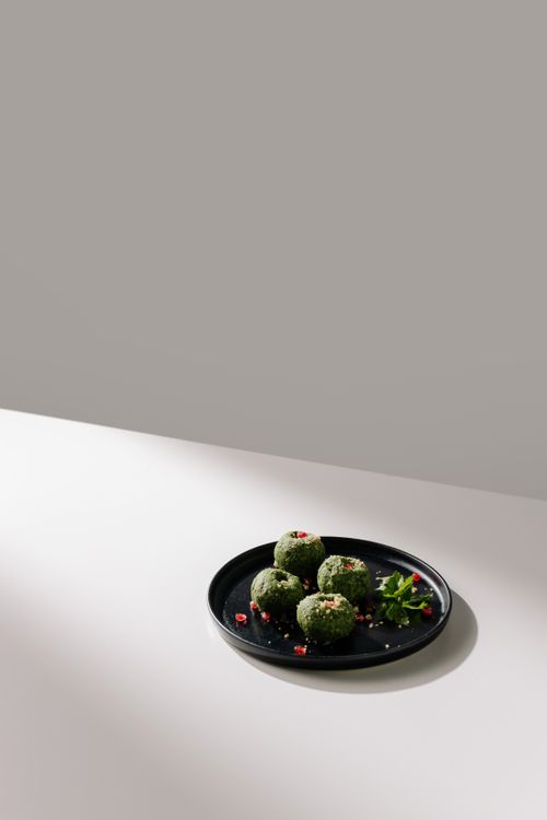 Free A minimalist composition showcasing traditional Georgian pkhali on a black plate. Stock Photo