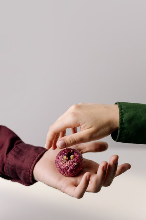 Free A minimalist shot of hands presenting a traditional beetroot pkhali, perfect for culinary and lifestyle themes. Stock Photo