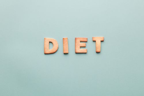 Free Alphabet cookies spelling 'diet' on a soft turquoise background, shot as a flat lay. Stock Photo