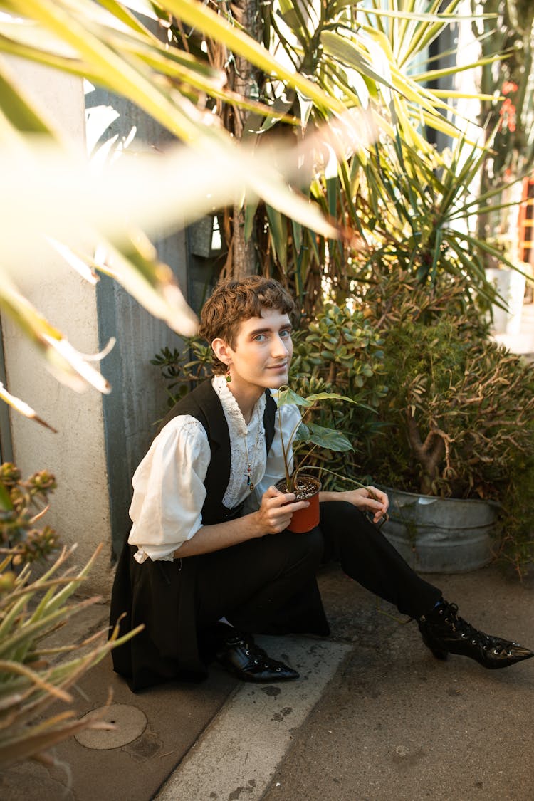 A Person Holding A Potted Plant