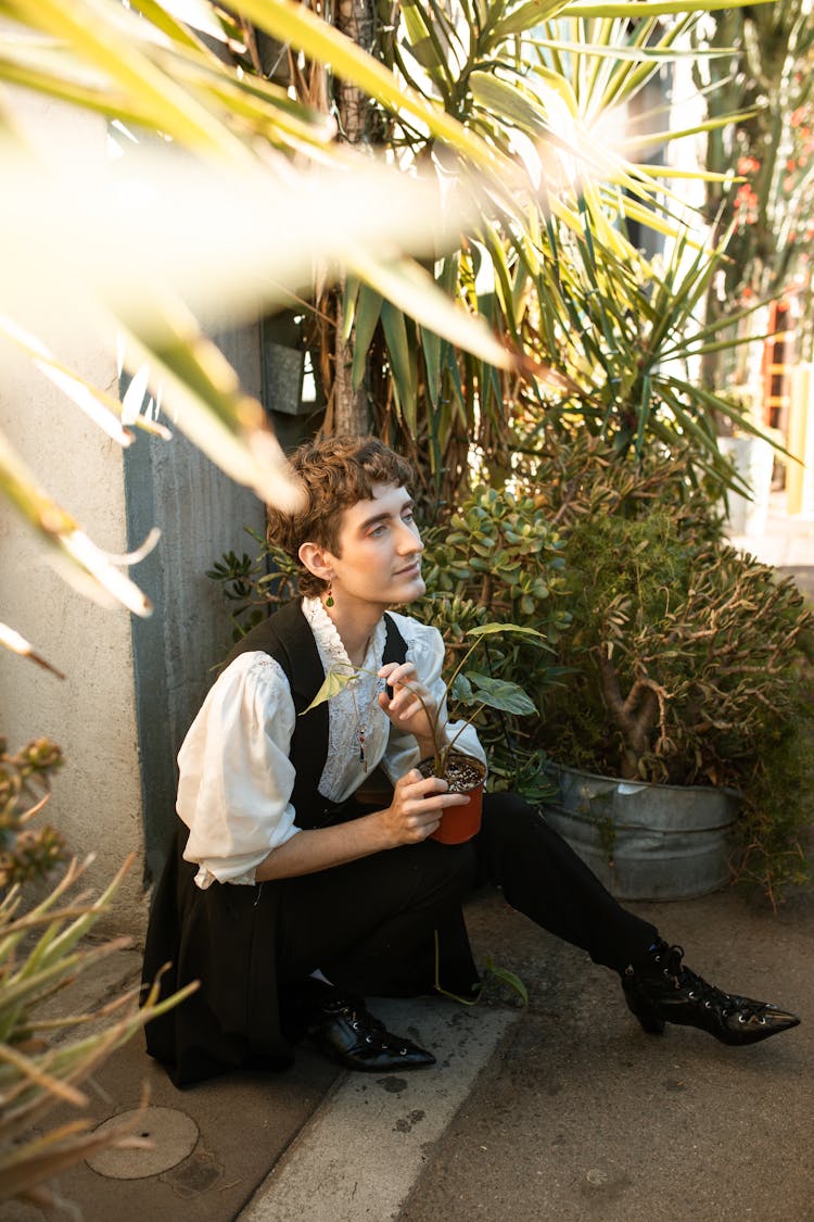 Stylish Person Sitting Beside Plants 