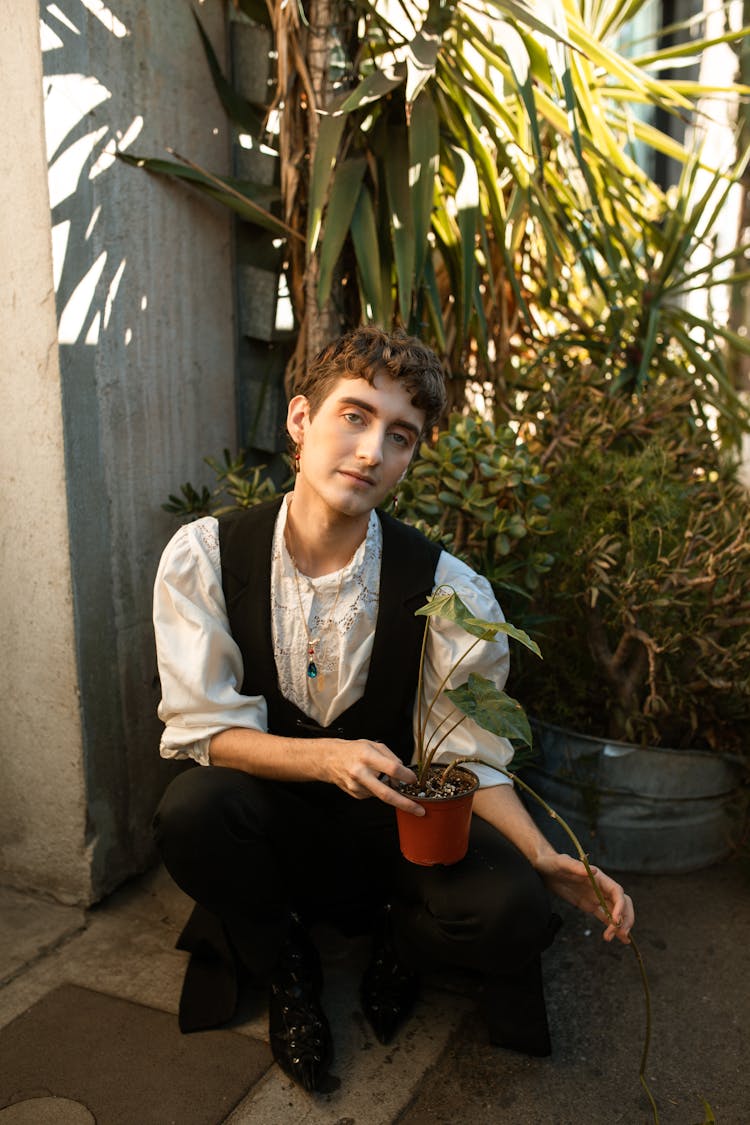 A Person Holding A Potted Plant