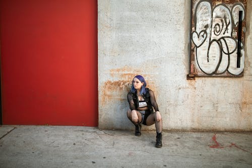 A Woman with Purple Hair Sitting on the Ground