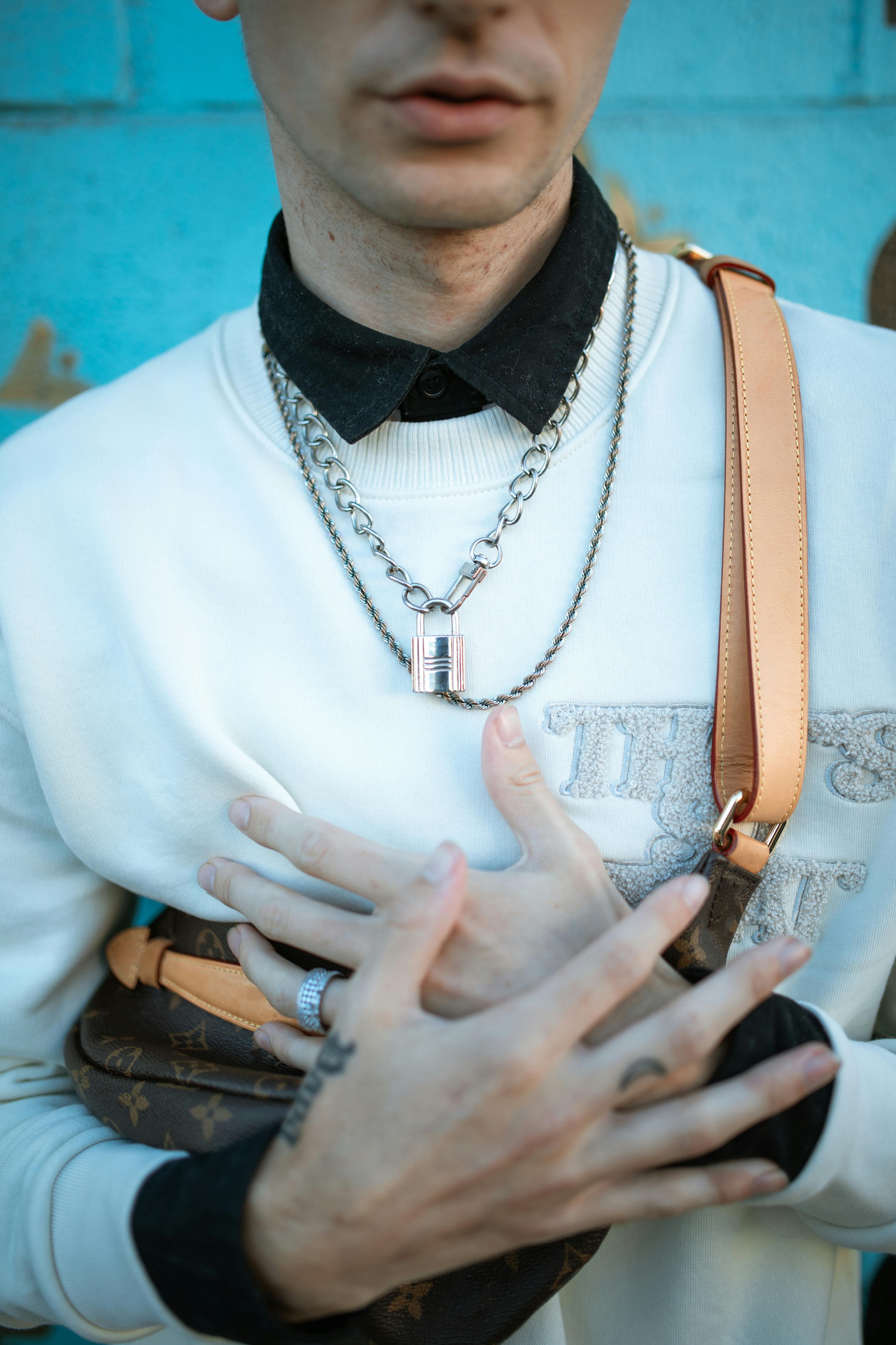 man in white crew neck t shirt wearing gold necklace