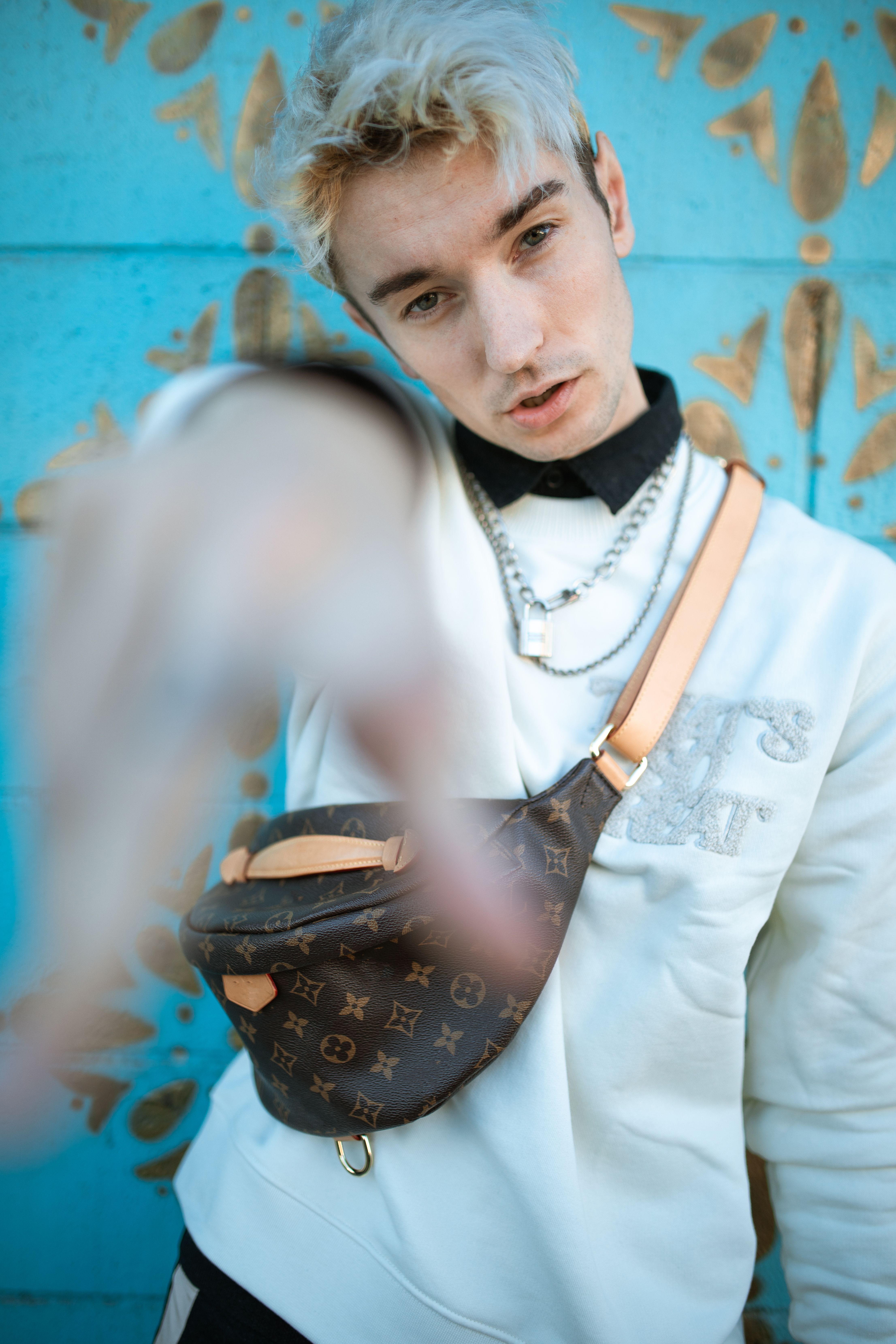 Stylish portrait of a young adult showcasing street fashion and accessories.