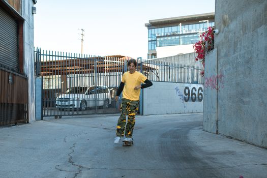 Man in Yellow Shirt and Camouflage Pants Riding on a Skateboard 