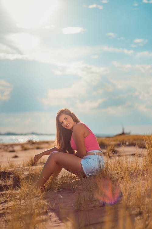 Woman in Tank Top Sitting on Brown Grass