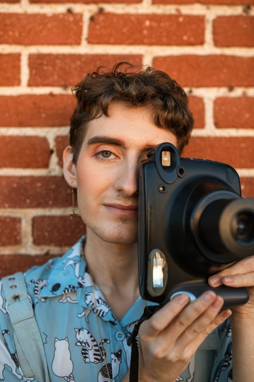 Man in Blue Button Up Shirt Holding Black Camera
