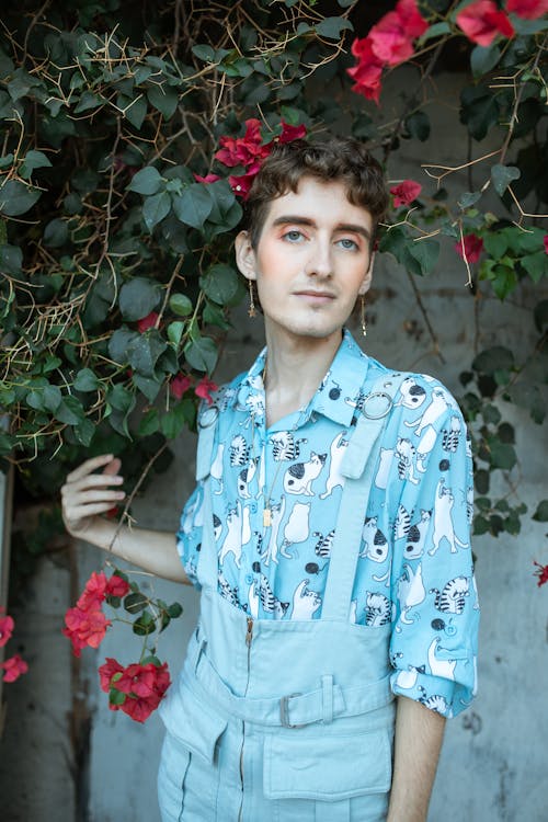 Homme En Chemise Boutonnée à Fleurs Bleu Et Blanc Debout à Côté De Fleurs Rouges