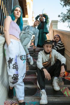 Vibrant group of Gen Z friends showcasing street style and fashion on colorful urban stairs.