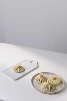 Elegant arrangement of traditional Georgian khinkali dumplings on minimalist plates.