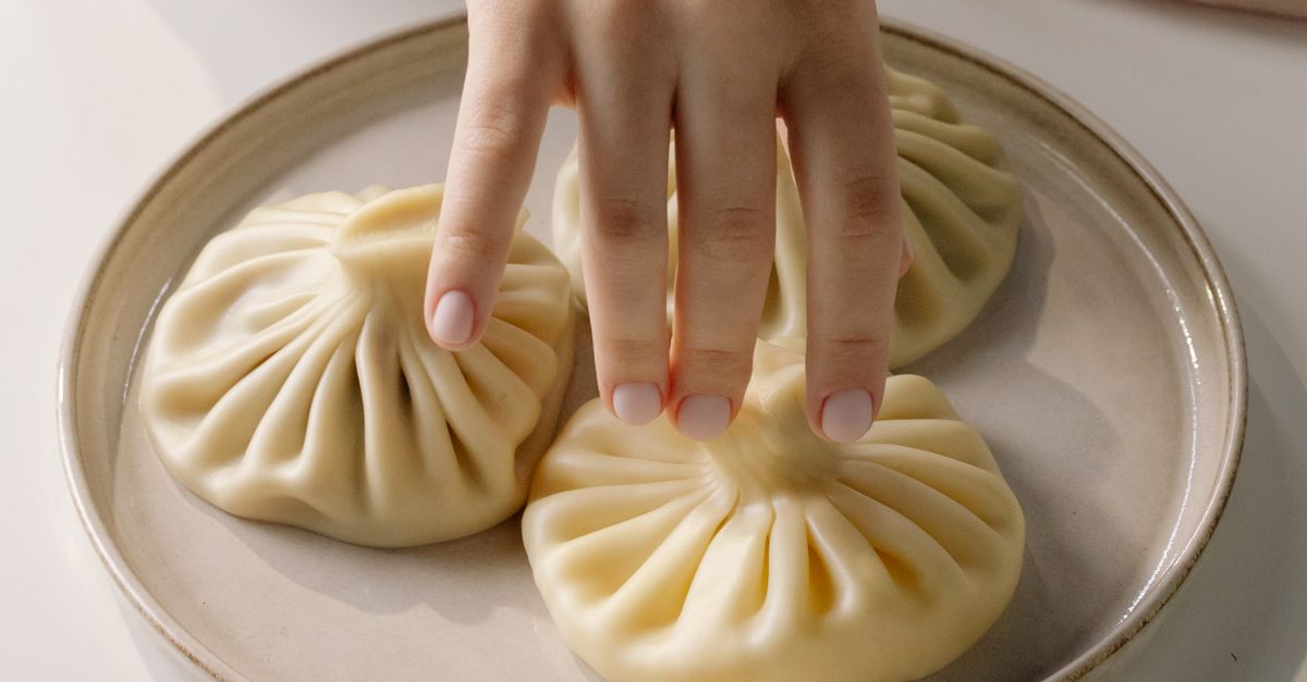 Dumpling Hand Close-Up Shot of a Person Holding a Dumpling · Free Stock Photo
