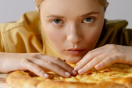 Intense gaze of a woman closely examining a delicious pizza, creating a mouthwatering scene.