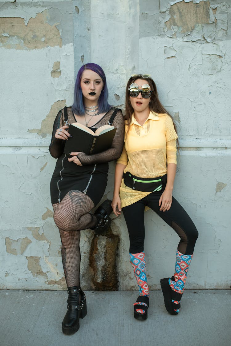 Two Women Leaning On Concrete Wall