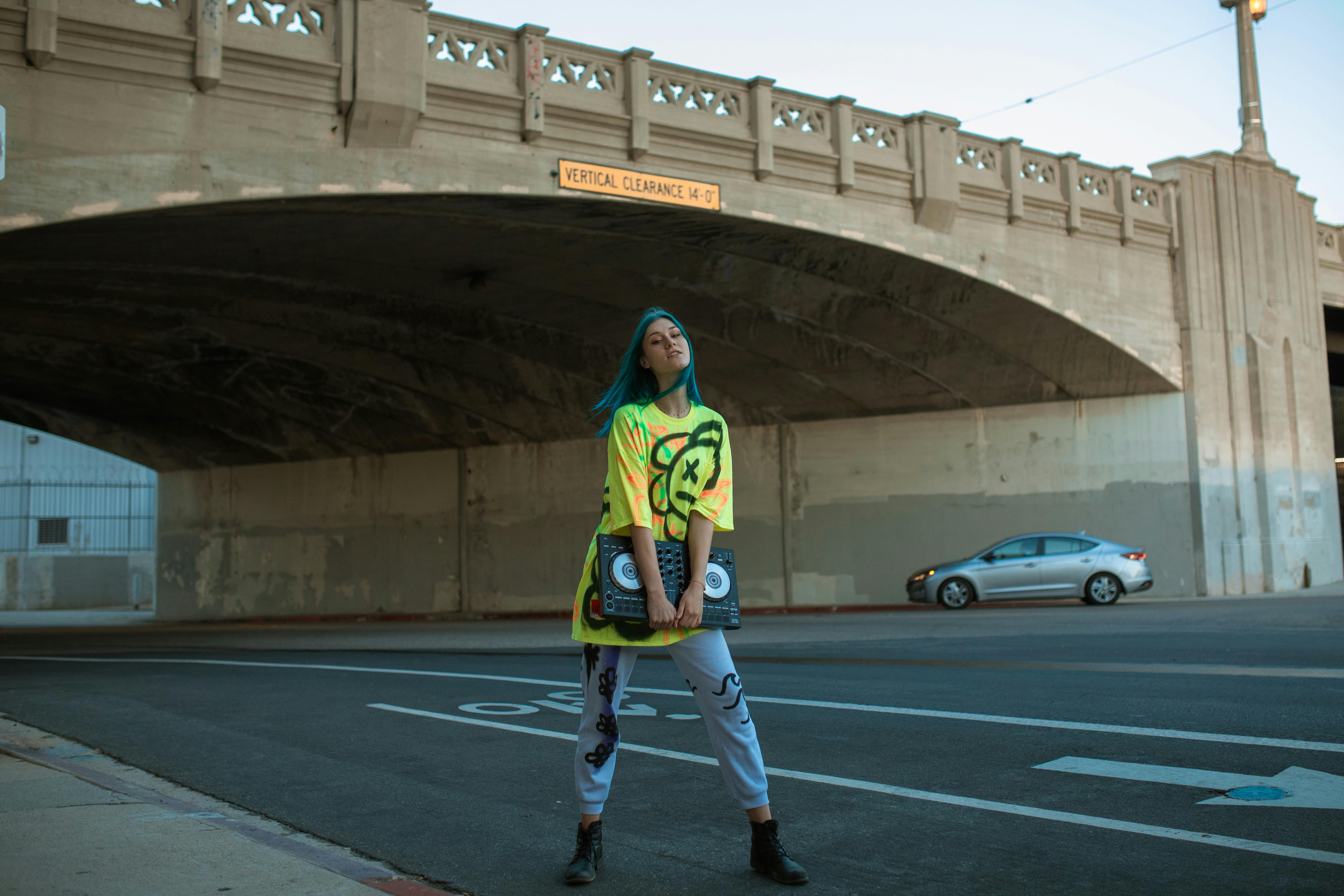 woman in green and yellow shirt standing on the road