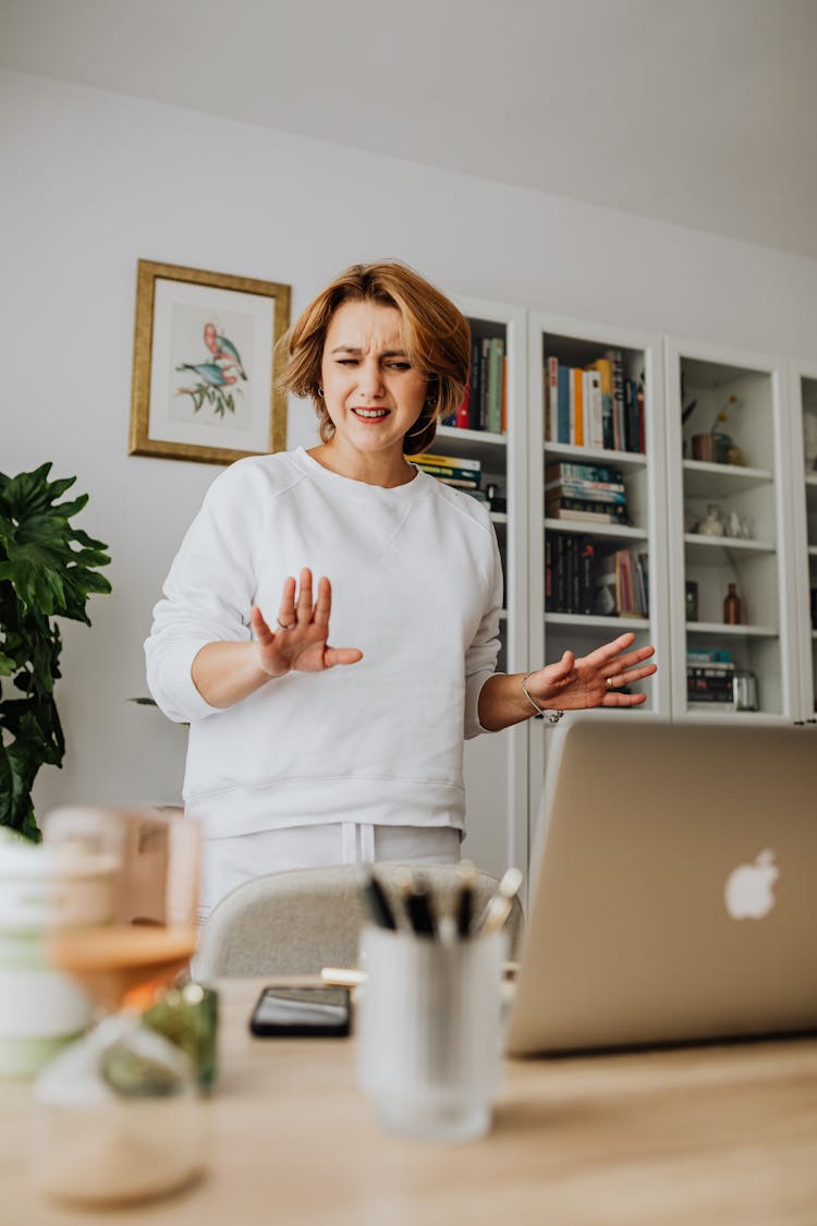 Appalled Woman Standing By Desk With Laptop