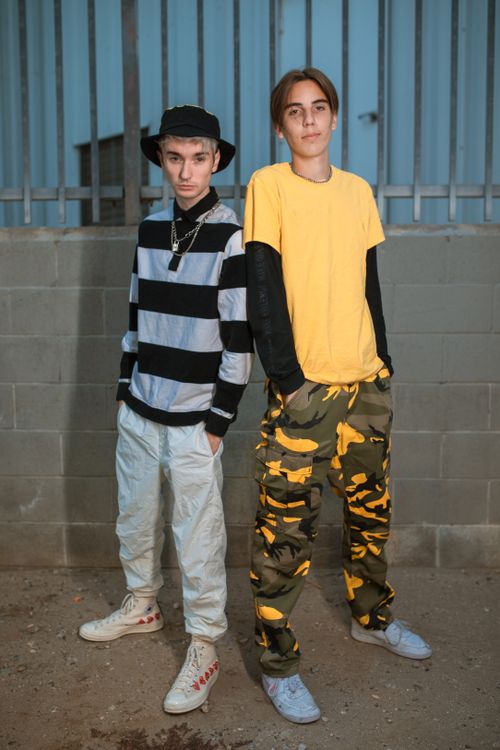 Free Fashionable teenagers in urban setting wearing trendy outfits with striped and camo patterns. Stock Photo