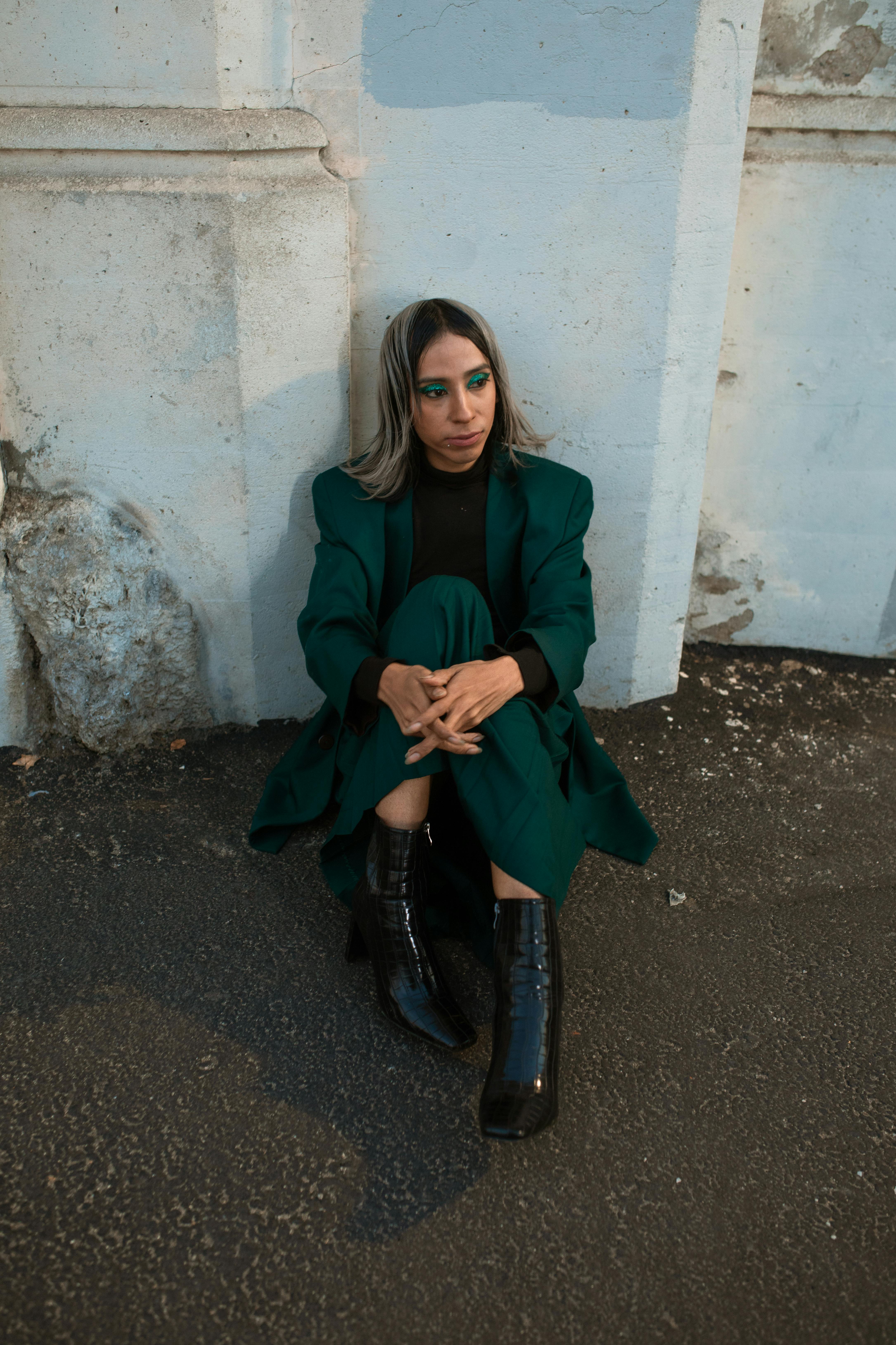 woman in green coat sitting on the floor