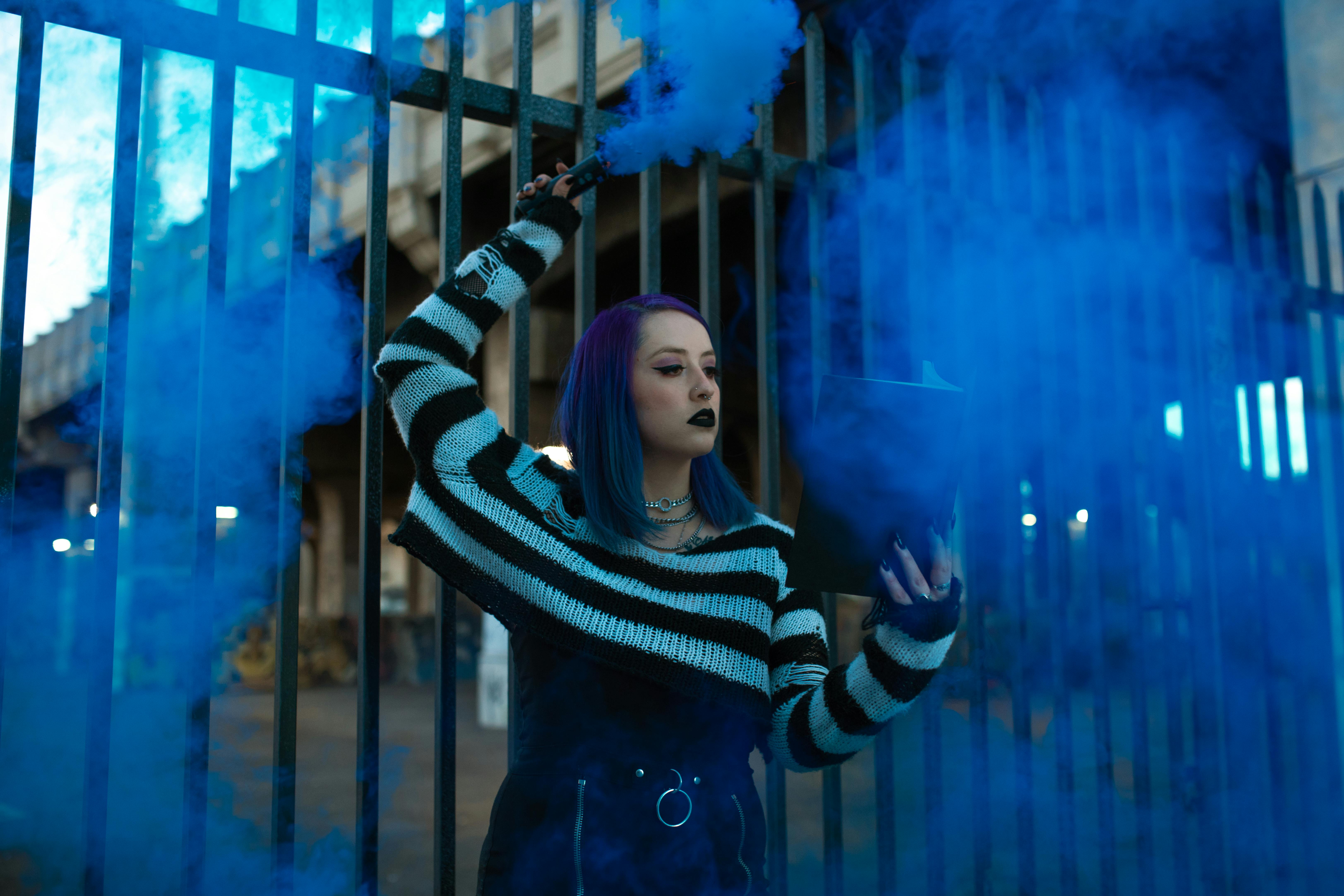 woman in black and white striped long sleeve shirt standing near blue lights