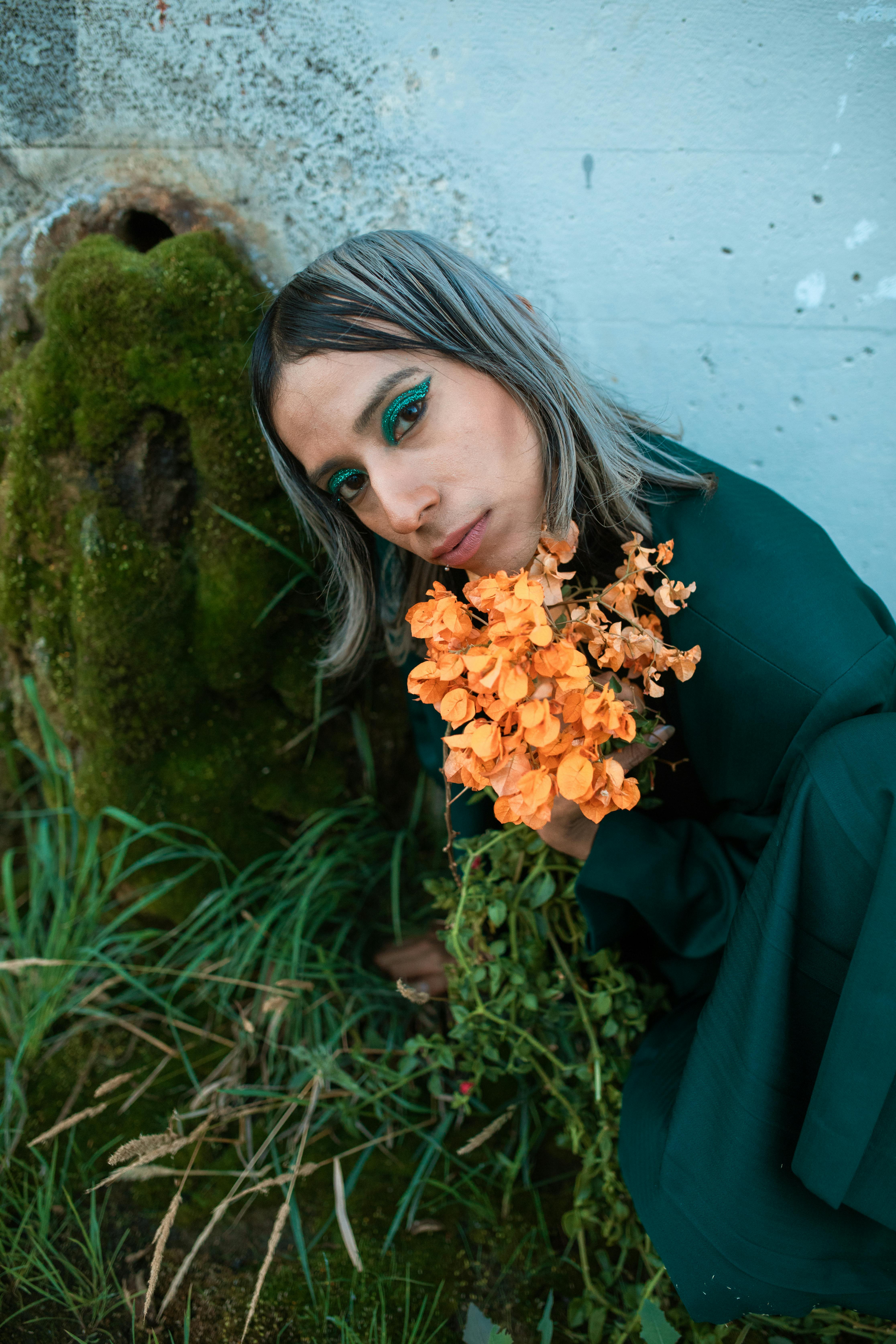 woman in black long sleeve shirt holding yellow flowers