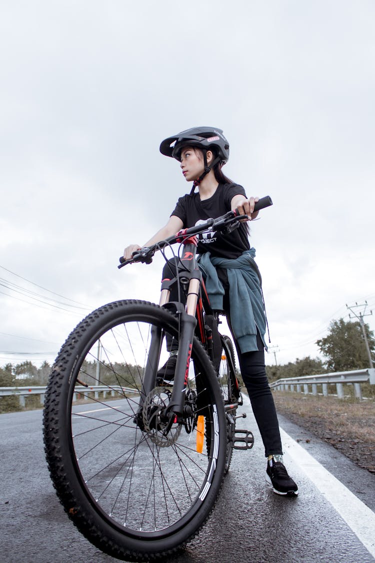 Woman In Helmet Seated On Bike