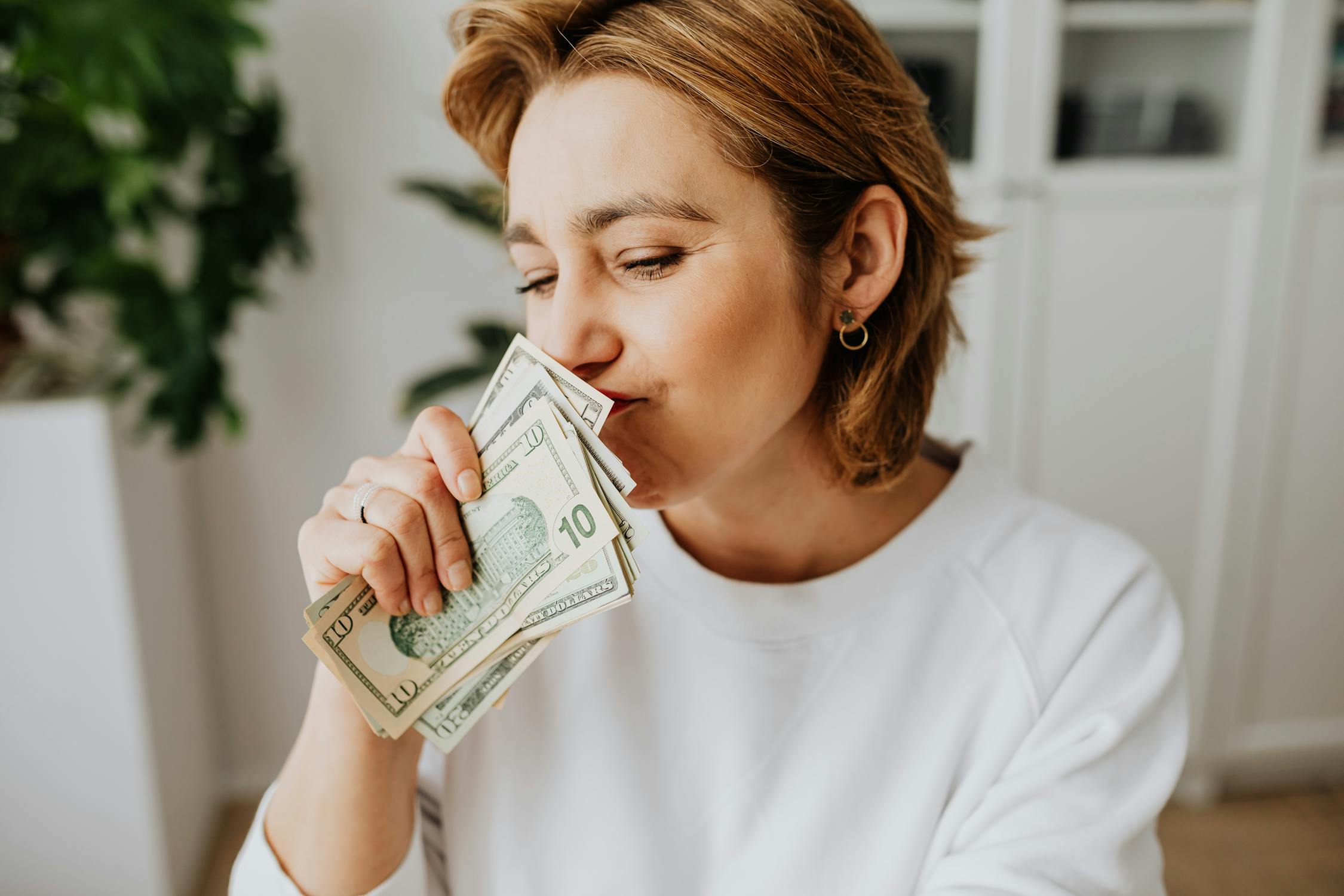 Woman Wearing Sweater Holding Dollar Bills