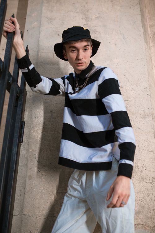 Free Stylish young adult in black and white stripes poses outdoors, exuding modern street fashion vibes. Stock Photo