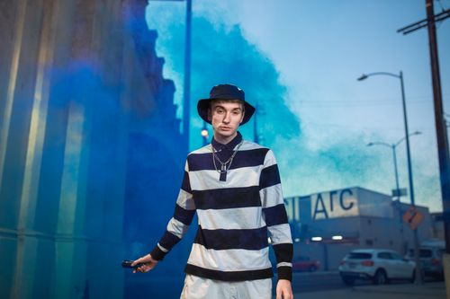 Free Trendy Gen Z individual with a smoke bomb, showcasing urban street style. Stock Photo