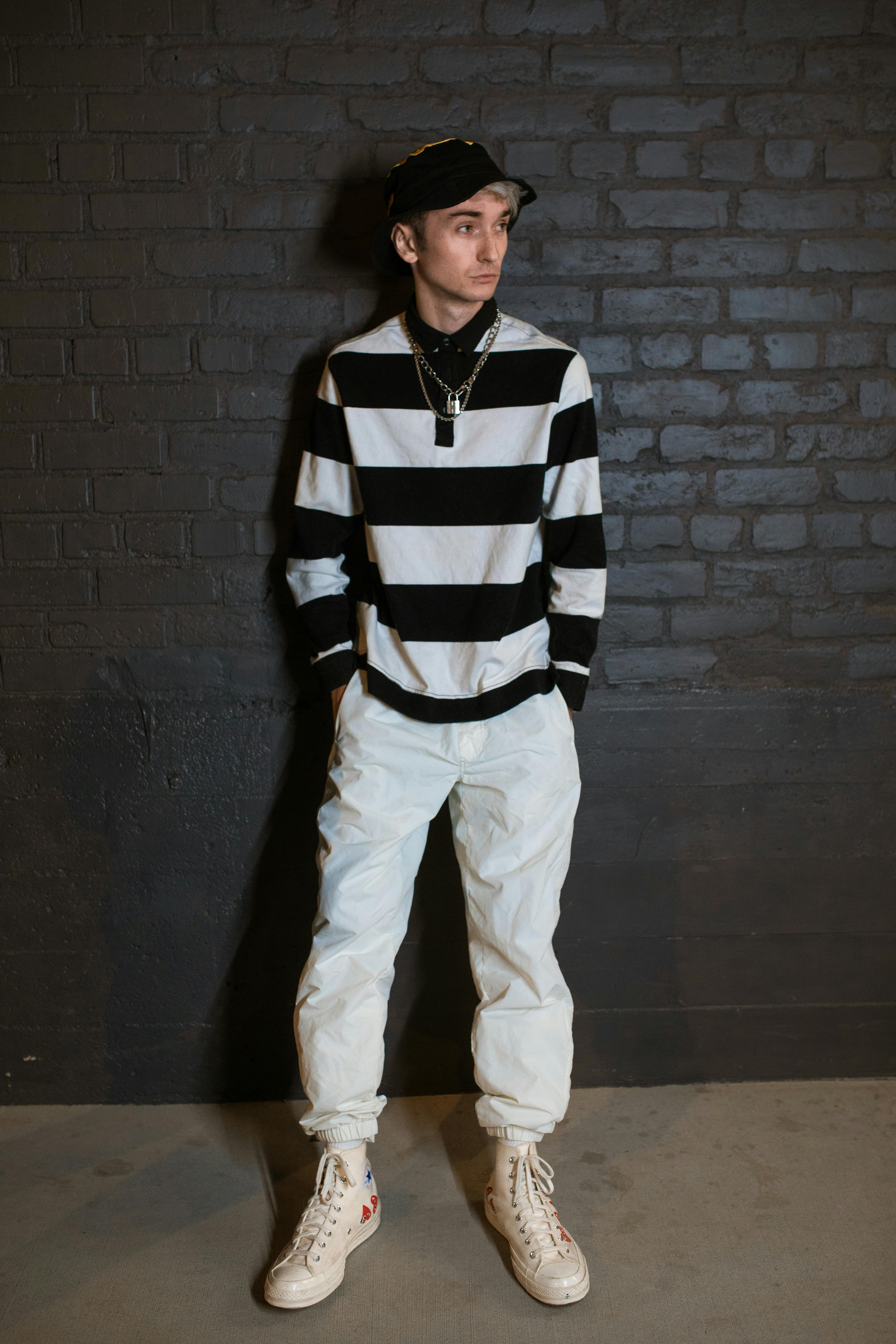 man in black and white striped long sleeve shirt and white pants