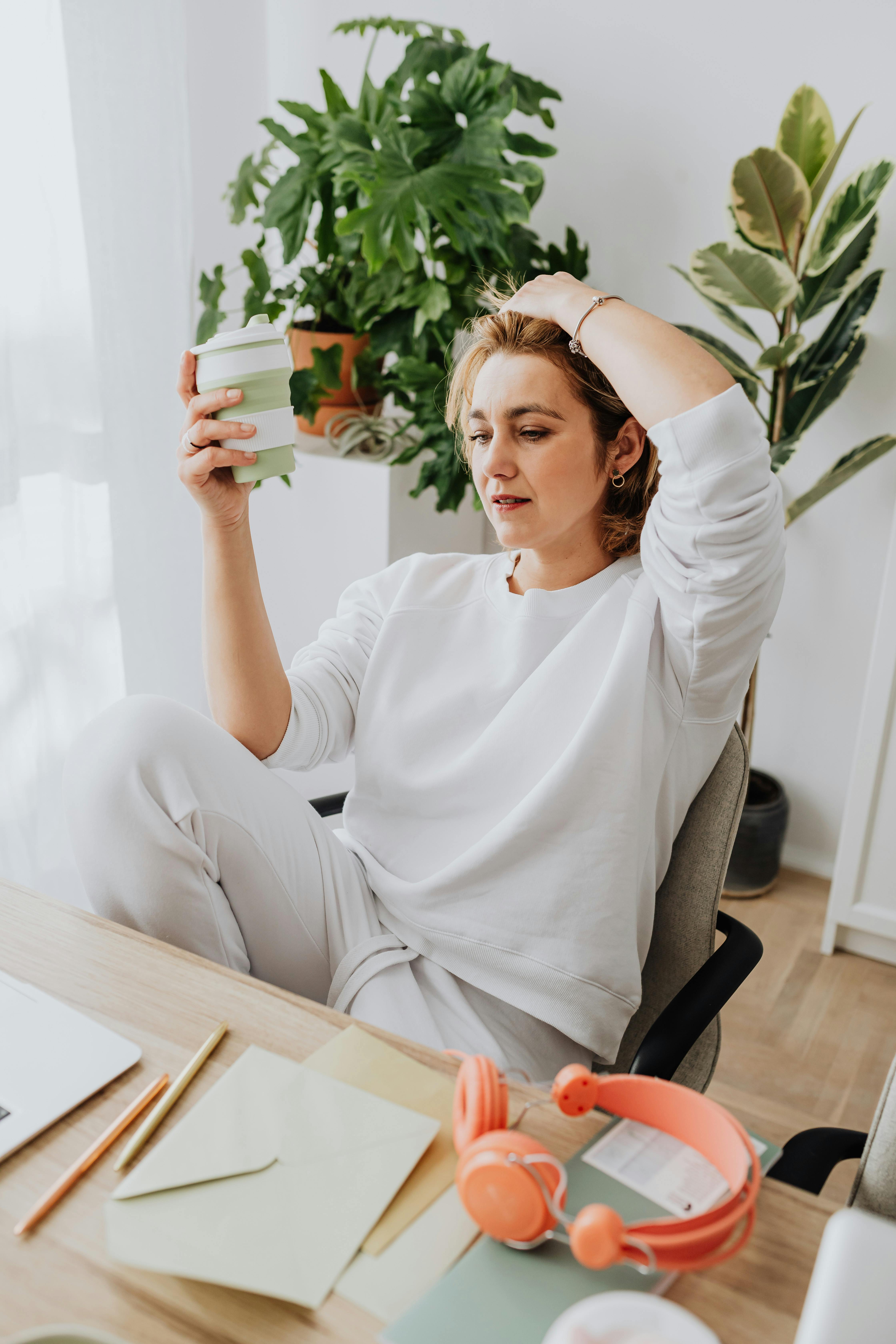 woman holding cup working from home