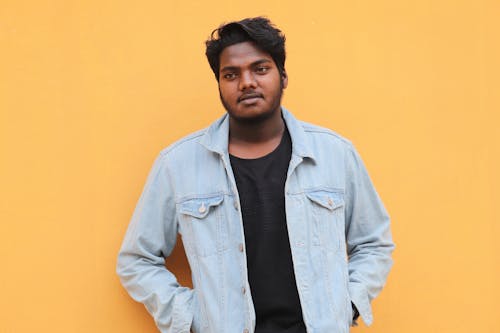 Photo of a Man Wearing a Denim Jacket and a Black Crew Neck Shirt