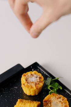 Close-up of gourmet vegetable tartlets spiced with salt, served with fresh parsley garnish.