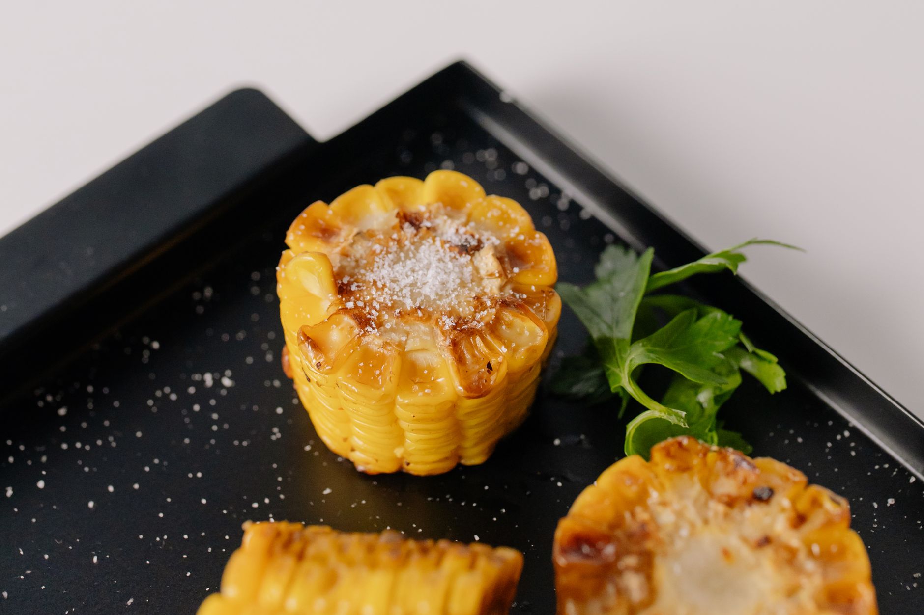 Corn on the cob brushed with Parmesan cheese and herbs