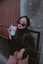 Woman in Black Leather Jacket Holding White Box