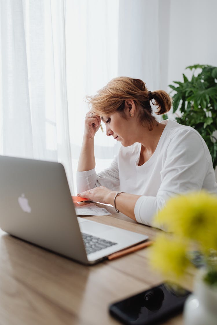 Worried Woman Sitting In An Office In Front Of Her Laptop 