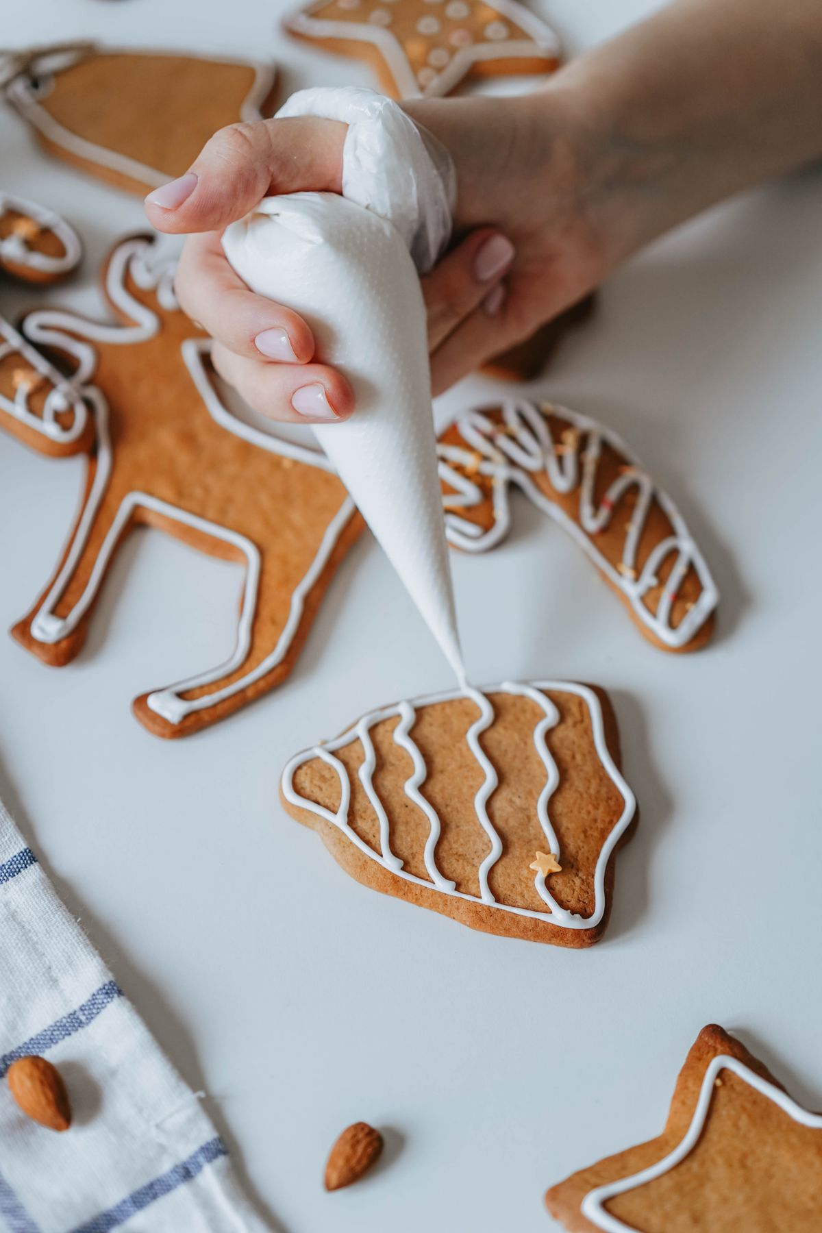 Woman decorating gingerbread cookies for ugly sweater cookie party
