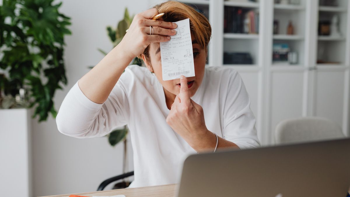 Businesswoman showing a receipt during a home office work session, highlighting technology integration.