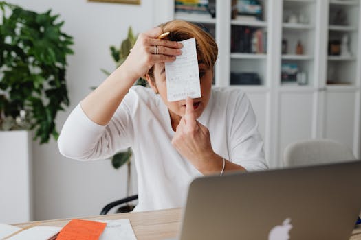 Businesswoman showing a receipt during a home office work session, highlighting technology integration.