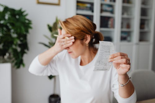 Unhappy Woman Holding Bill