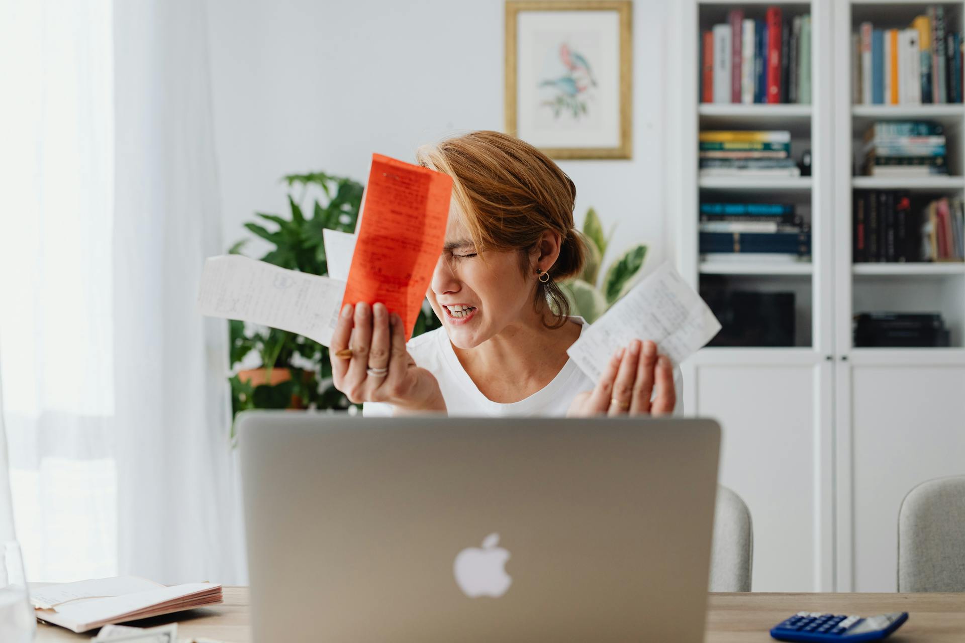 Woman Crying while Holding Bills in her Hands