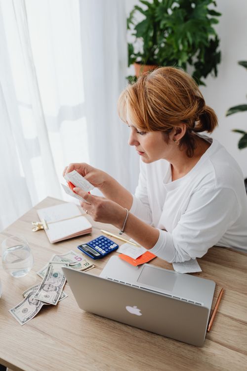 woman calculating budget laptop receipts