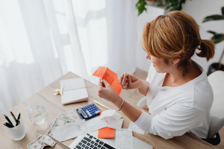 person organizing receipts and using a calculator next to a laptop showing a spreadsheet - adu tax credit california person organizing receipts and using a calculator next to a laptop showing a spreadsheet - adu tax credit california
