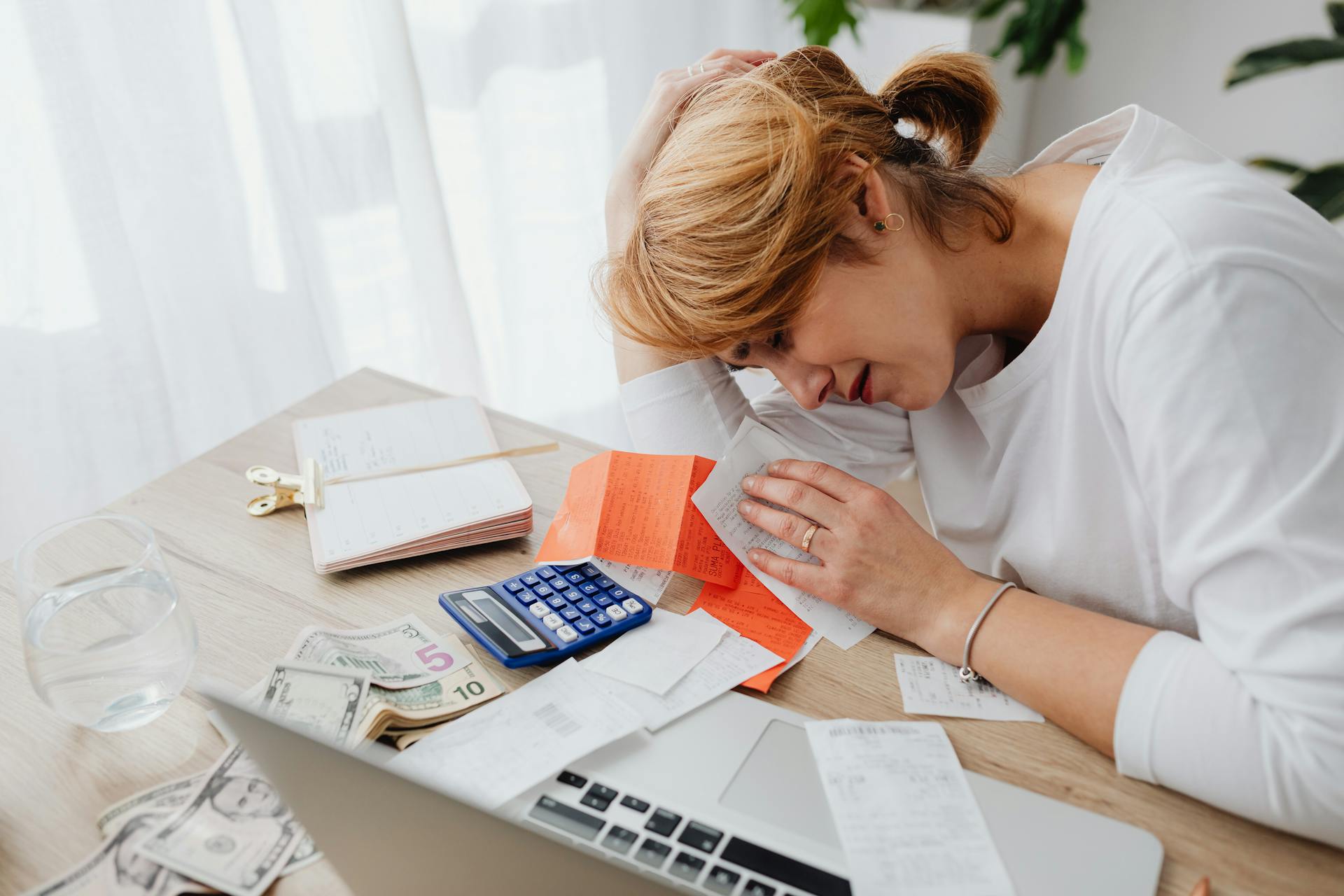 Woman Sitting at the Desk with Receipts